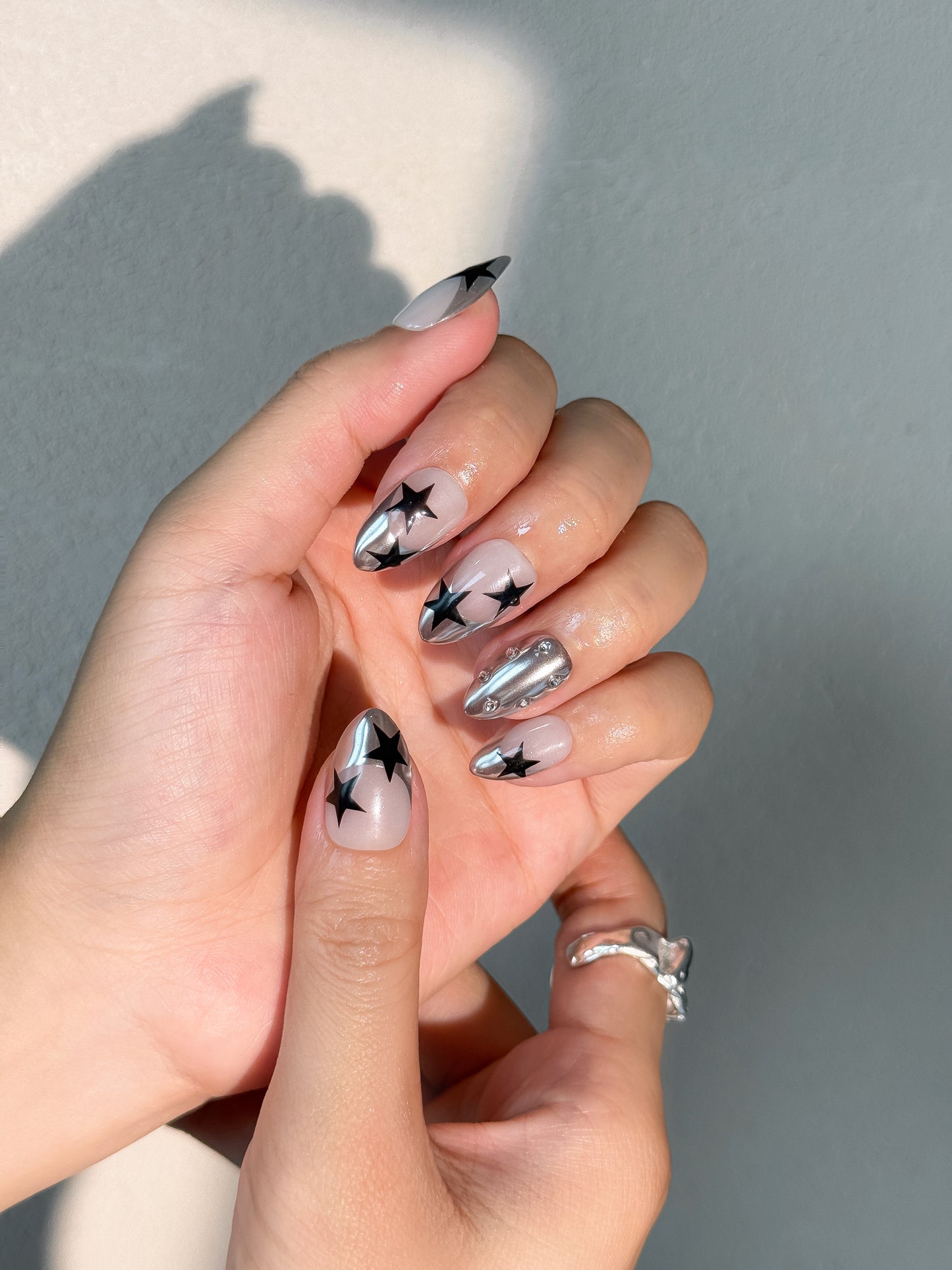 Manucure futuriste noire et métallique, modèle Stellar Riot par nailmusee