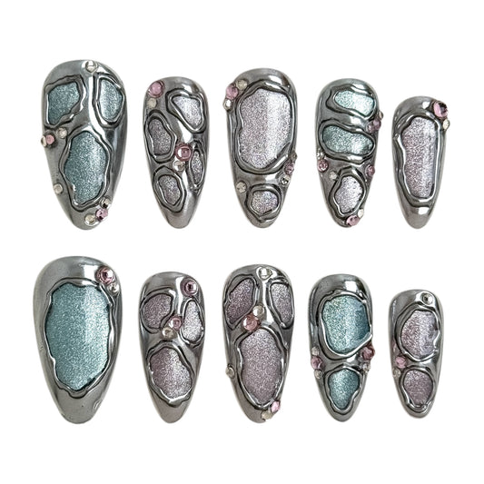 Détail des faux ongles Jolie Chrome avec finition chrome liquide et reflets nacrés bleutés et rosés