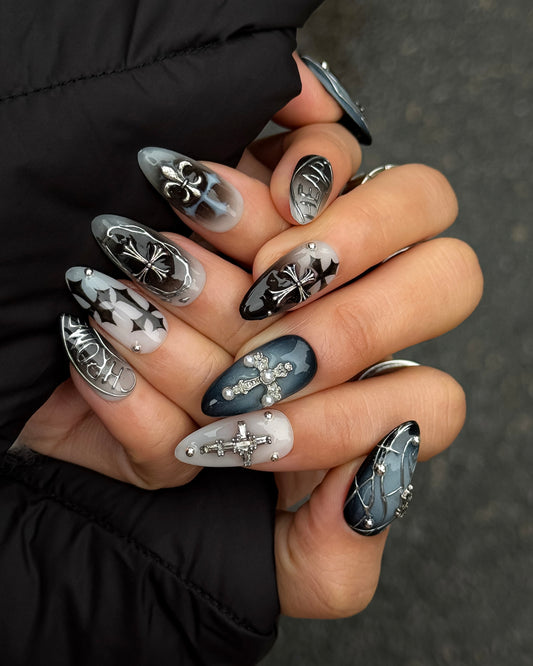 Détail des faux ongles Midnight Relique avec croix argentées métalliques et dégradé noir fumé