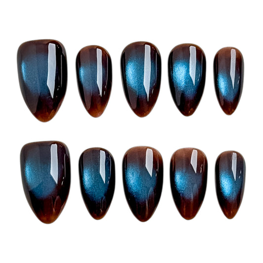 Ongles œil de chat bleu café avec base brun café et reflets bleus changeants