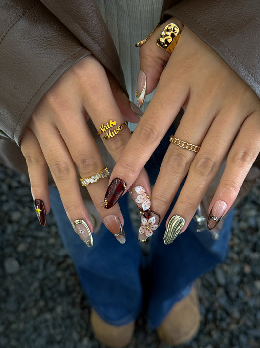 manucure fleur tardive, ongles marrons carmin et or doux par nailmusee