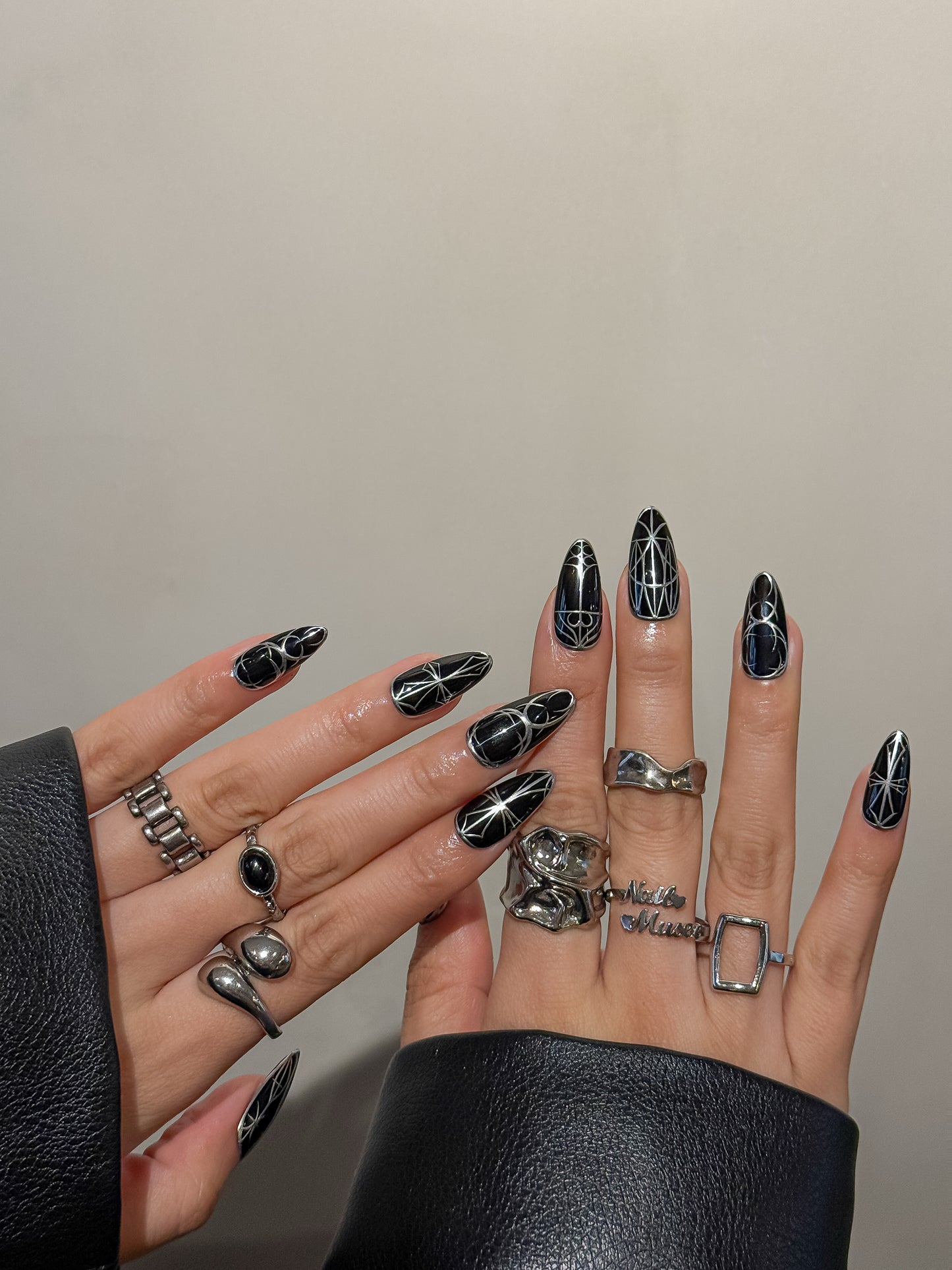 Ongles press-on noirs et argent portés, entièrement peints à la main