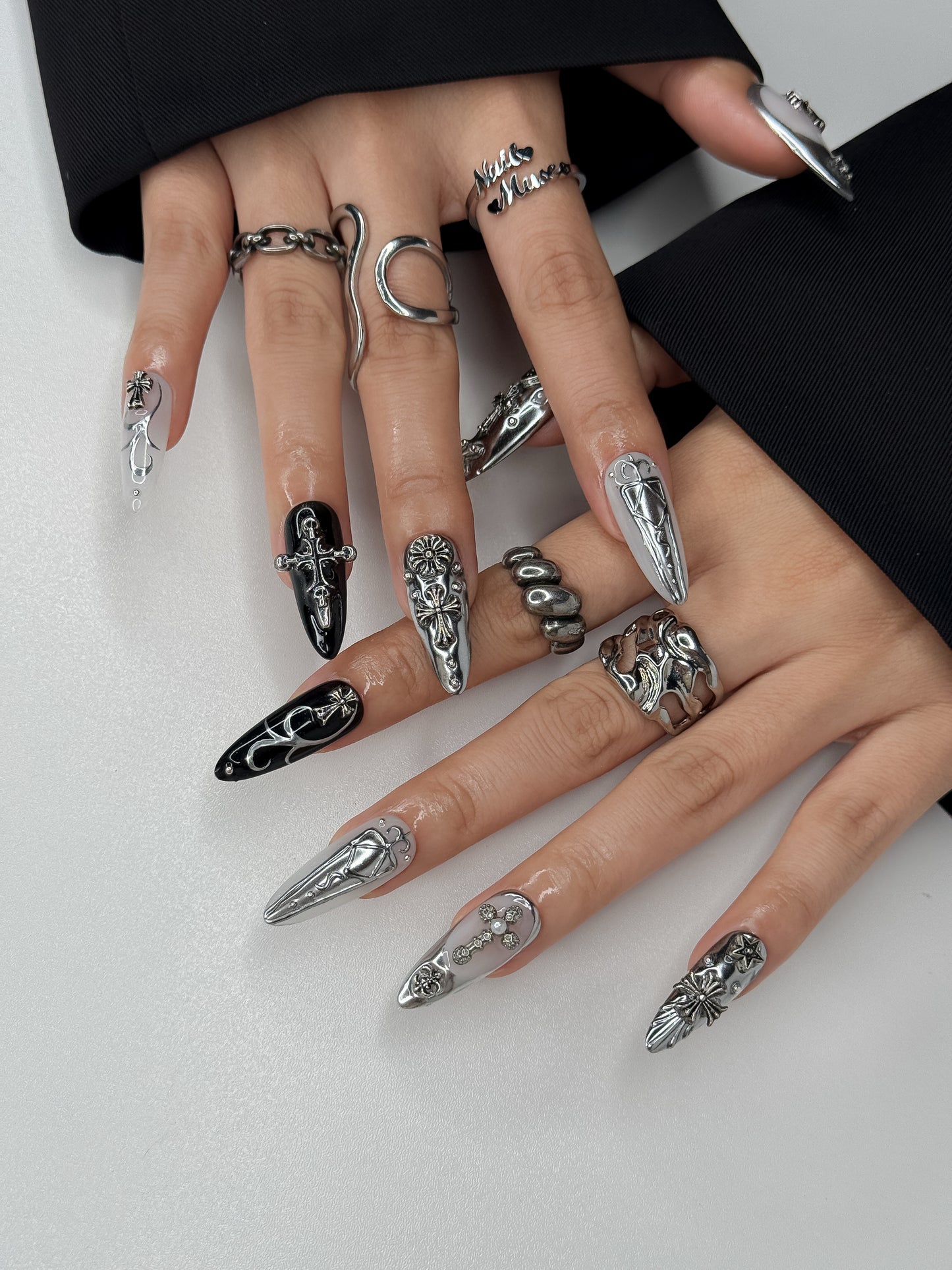 Close-up of Votive Silver gothic chrome press-on nails featuring silver cross details and dark luxury finish