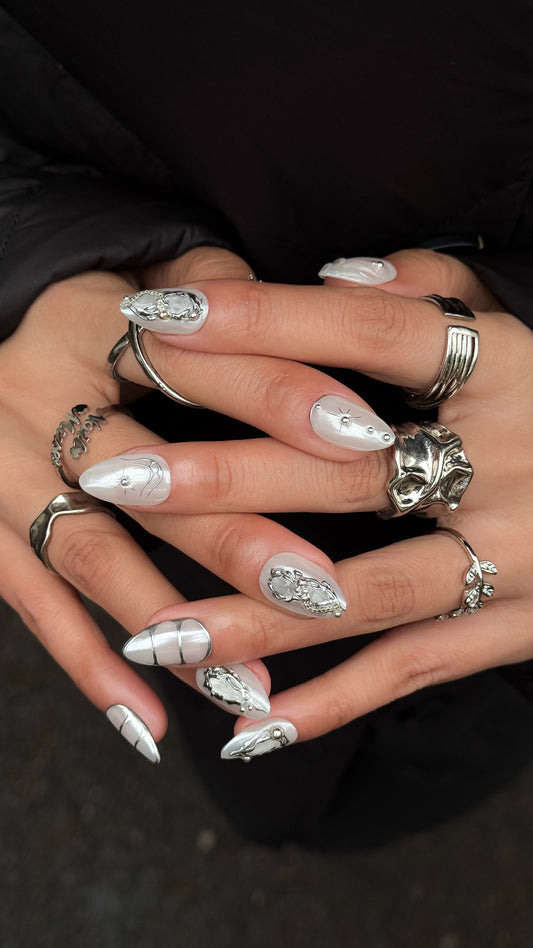 Faux ongles blanc chrome portés avec finition lumineuse et propre