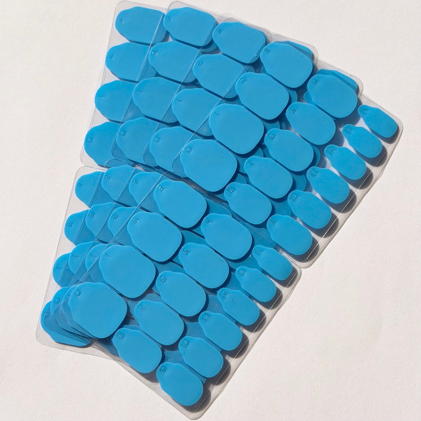 Pastilles adhésives bleues taille U adaptées aux ongles naturels longs.