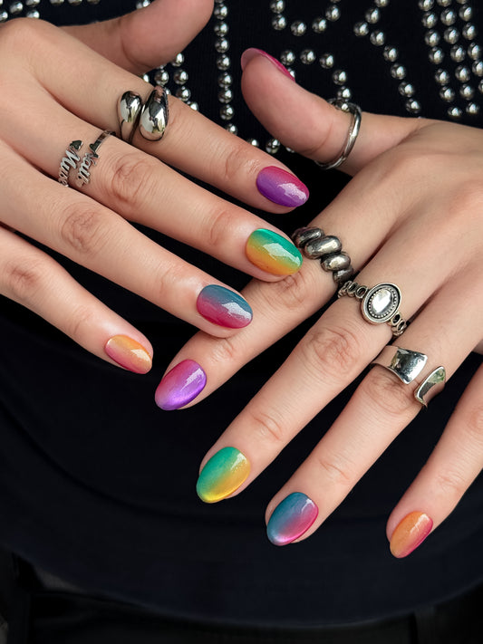 Détail des ongles press-on Rainbow Aura aux couleurs arc-en-ciel avec finition brillante et reflets nacrés.