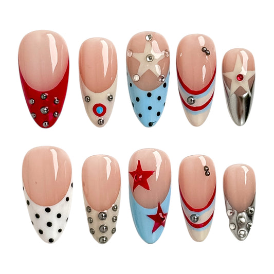 Rodeo Star press-on nails by NailMusee featuring retro Americana stars, polka dots, chrome accents and red, white and blue details.