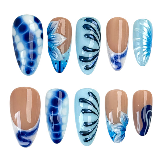 Faux ongles artisanaux bleu lagon avec fleurs peintes à la main et motifs inspirés de la mer.