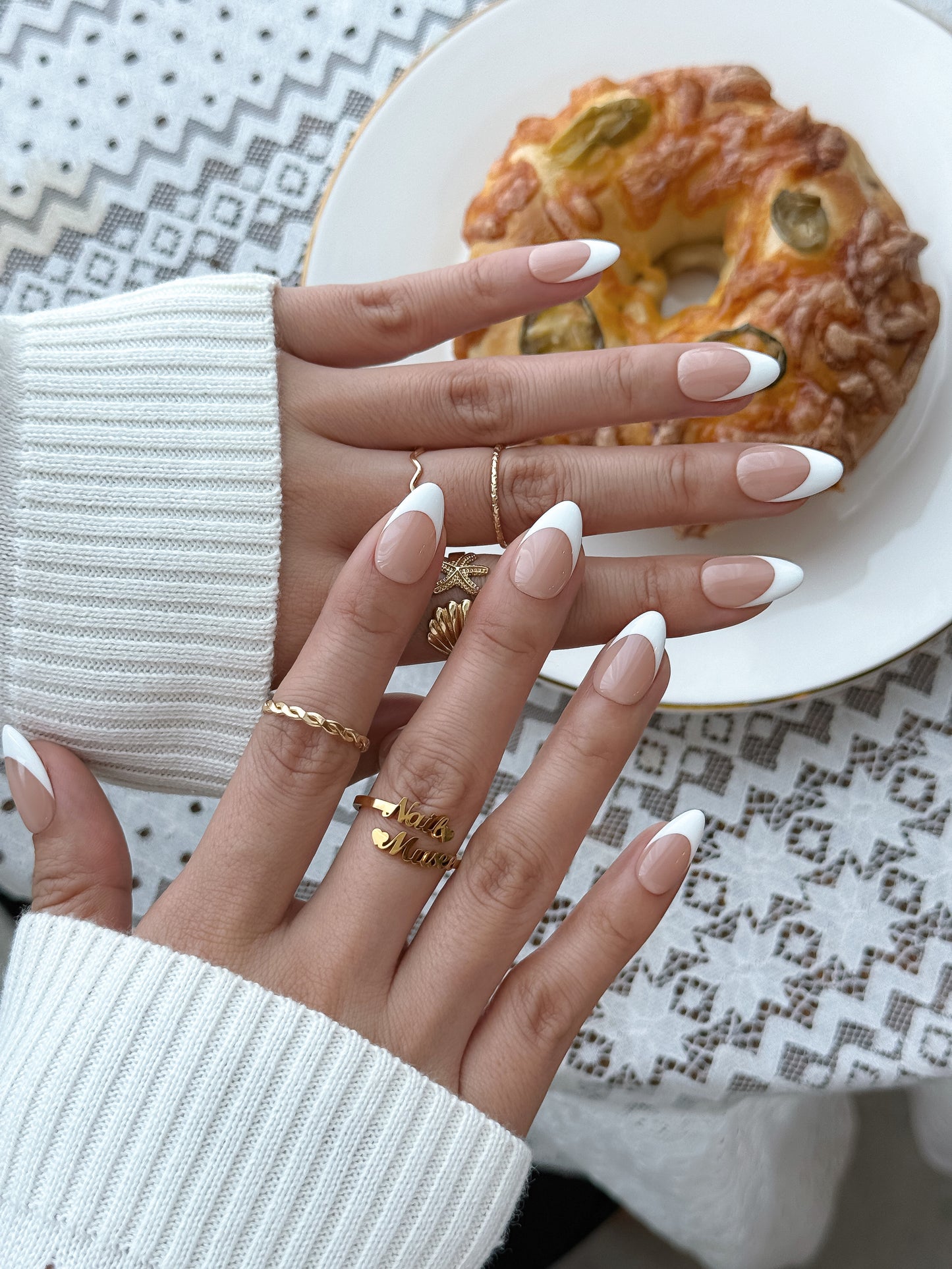 Woman wearing Blanc de Lune white French tip press-on nails with a short almond shape and glossy finish by NailMusee