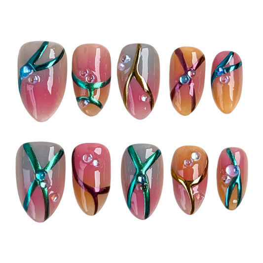 Press-on nails Bonbon faits main avec détails dorés, perles et nuances rose, caramel et bleu.