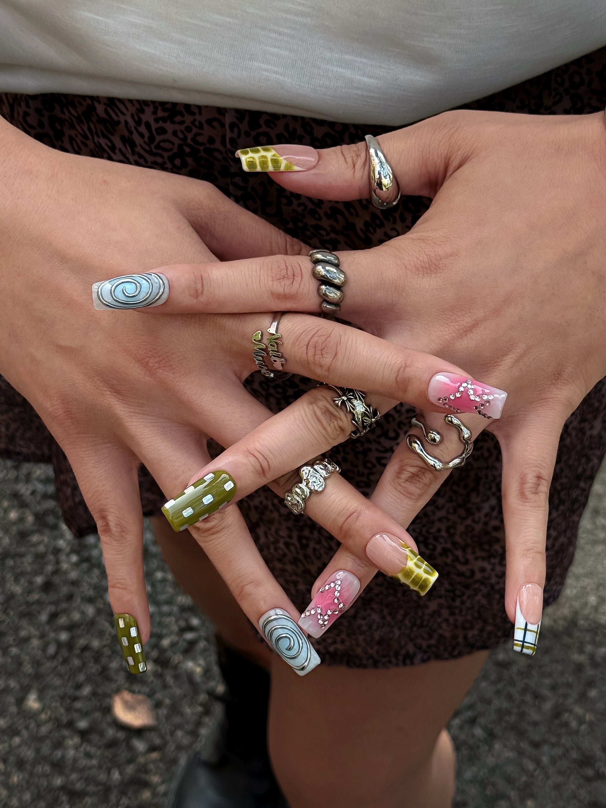 Handmade Y2K press-on nails featuring pink chrome details, checker patterns and sparkling rhinestones by NailMusee