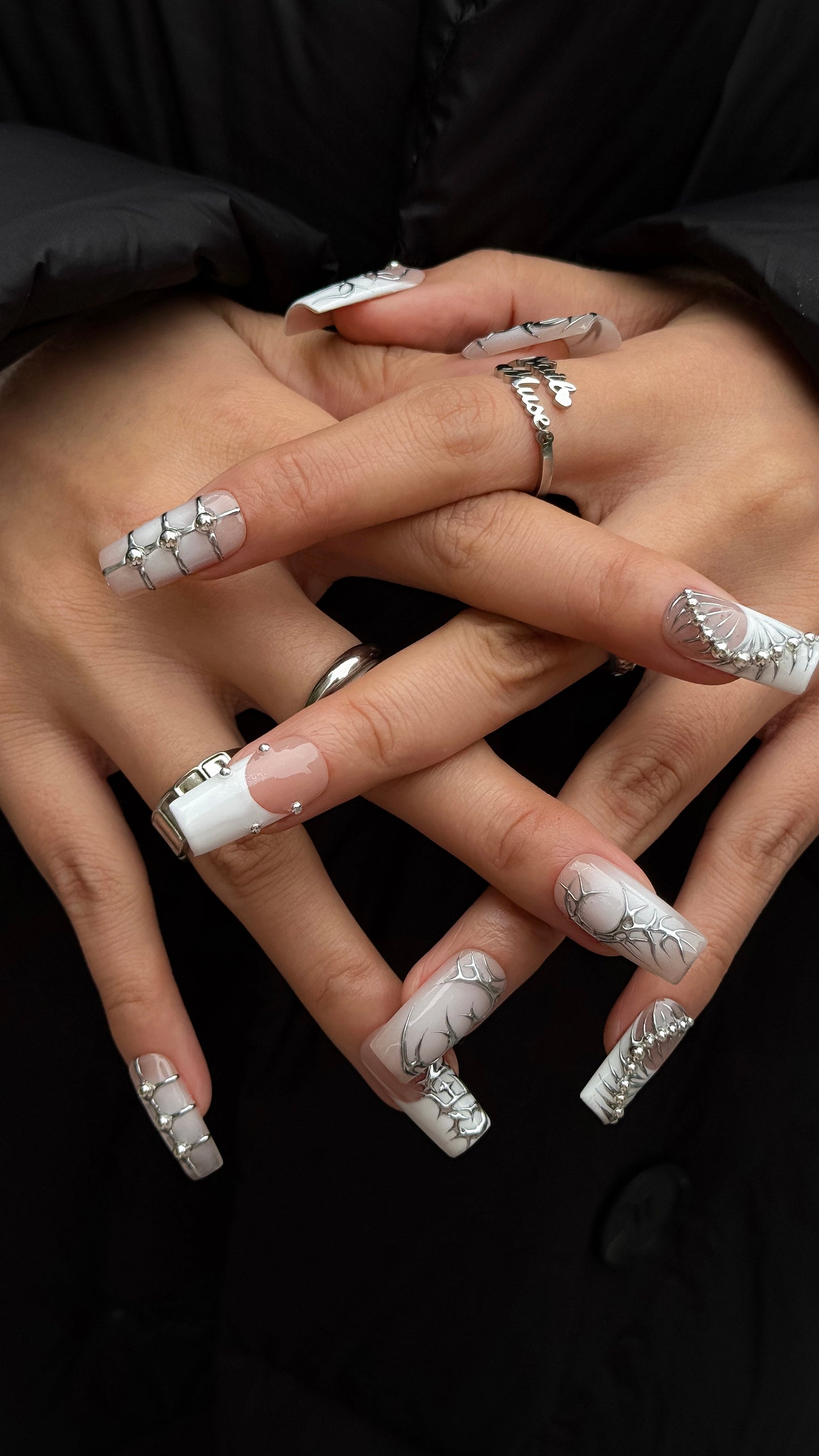 Handmade nude and chrome press-on nails with silver relief details and cool futuristic aesthetic by NailMusee