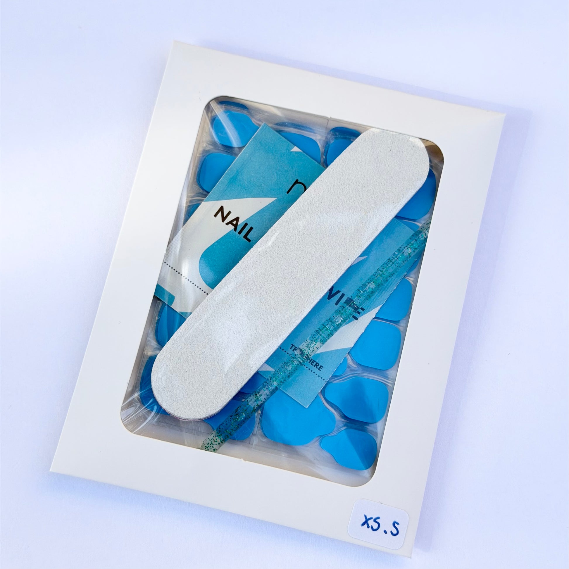 Kit de pose pour faux ongles avec gel pads bleus taille XS/S, lime à ongles, bâtonnet de manucure et lingette préparatrice.