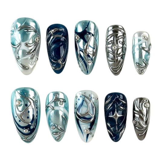faux ongles bleu chrome avec design abstrait et effet métal brillant