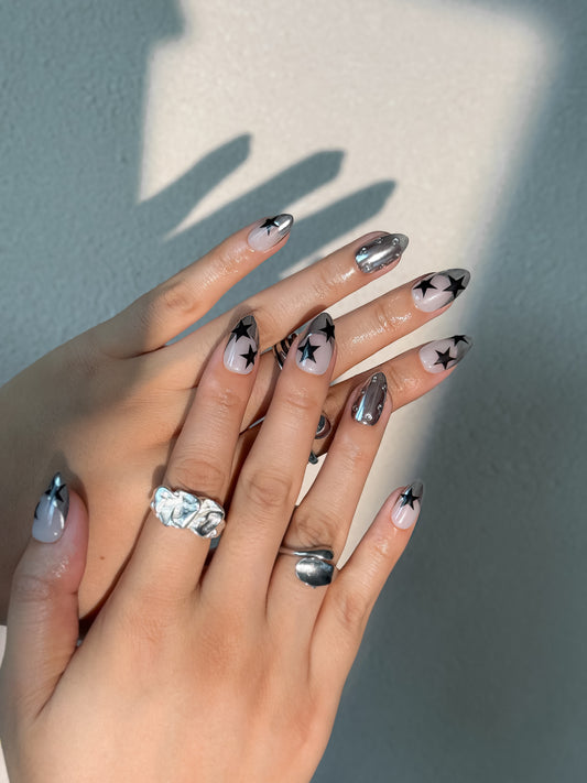 Design d’ongles audacieux : étoiles noires sur fond argenté chromé