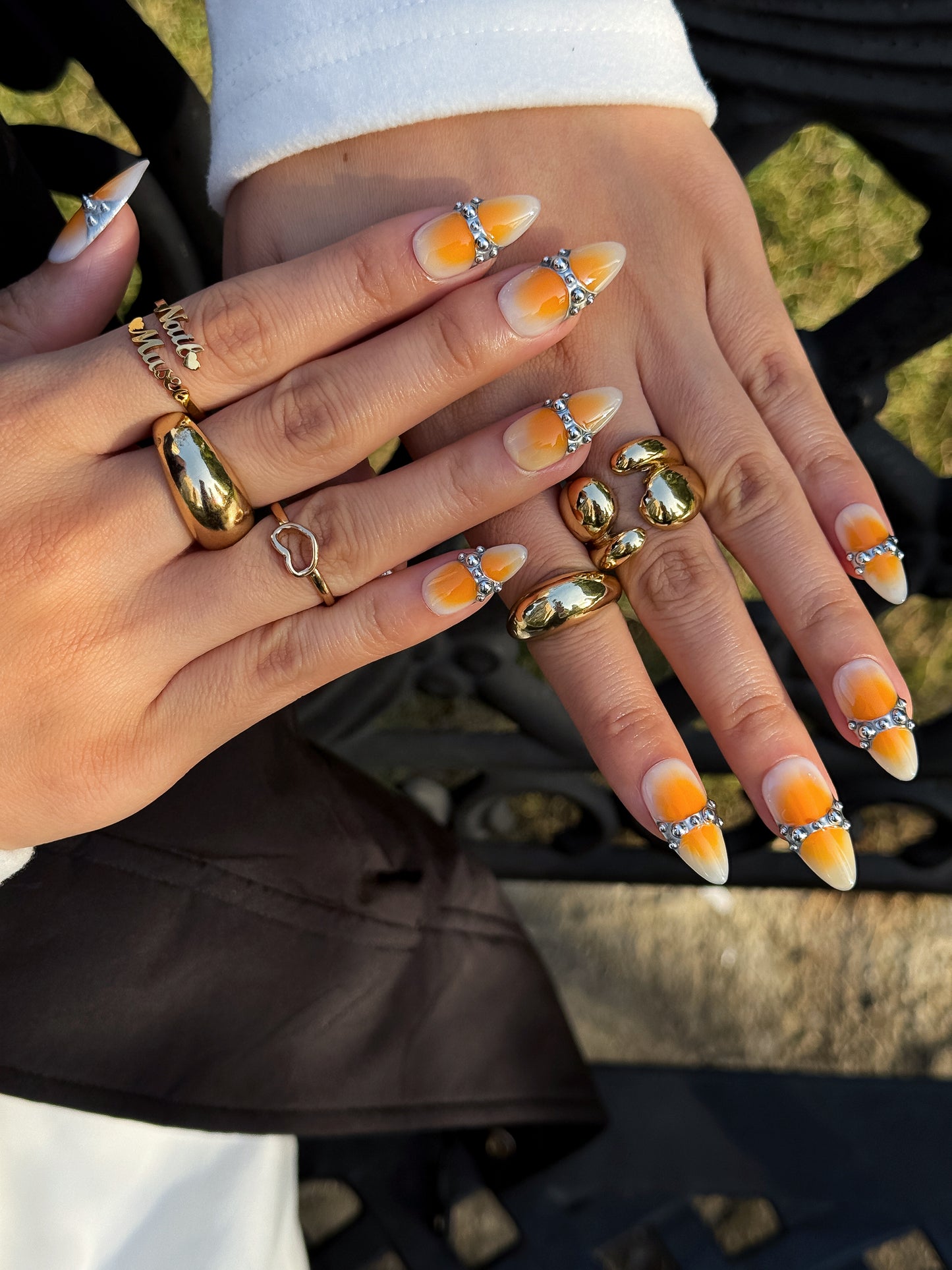 Manucure Mandarine Chrome portée sur la main