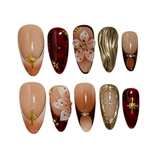 détail des motifs floraux dorés sur la manucure fleur tardive