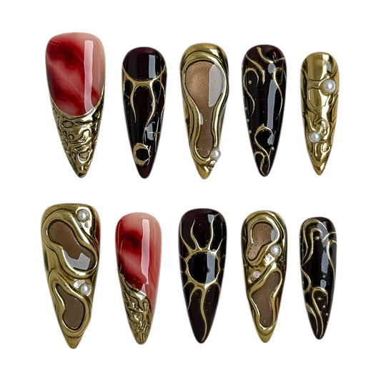 Ongles press-on Or Obscur bordeaux et or à effet métal liquide, forme amande, nail art luxe personnalisable.