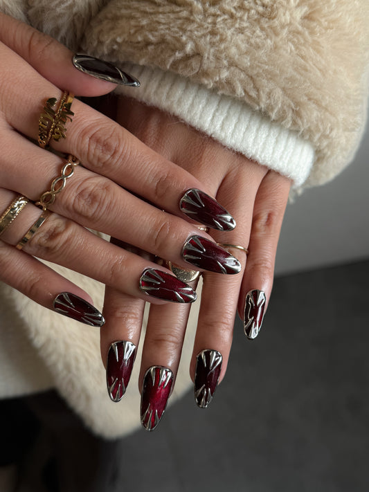 Faux ongles Saignée d’Argent portés, rouge grenat et finition chrome argenté NailMusee