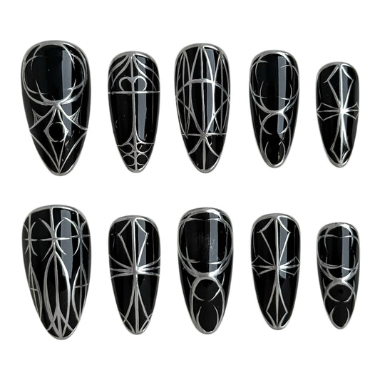Détail des lignes argentées peintes à la main sur ongle noir