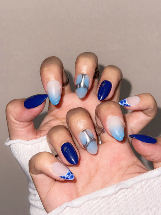 Ongles réutilisables Nailmusee Astra Nova avec motifs d’étoiles et reflets argentés