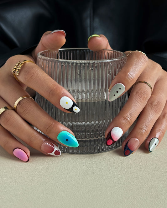 Ongles press-on Palette de Printemps portés sur les mains, manucure artistique aux tons pastel et finition brillante.