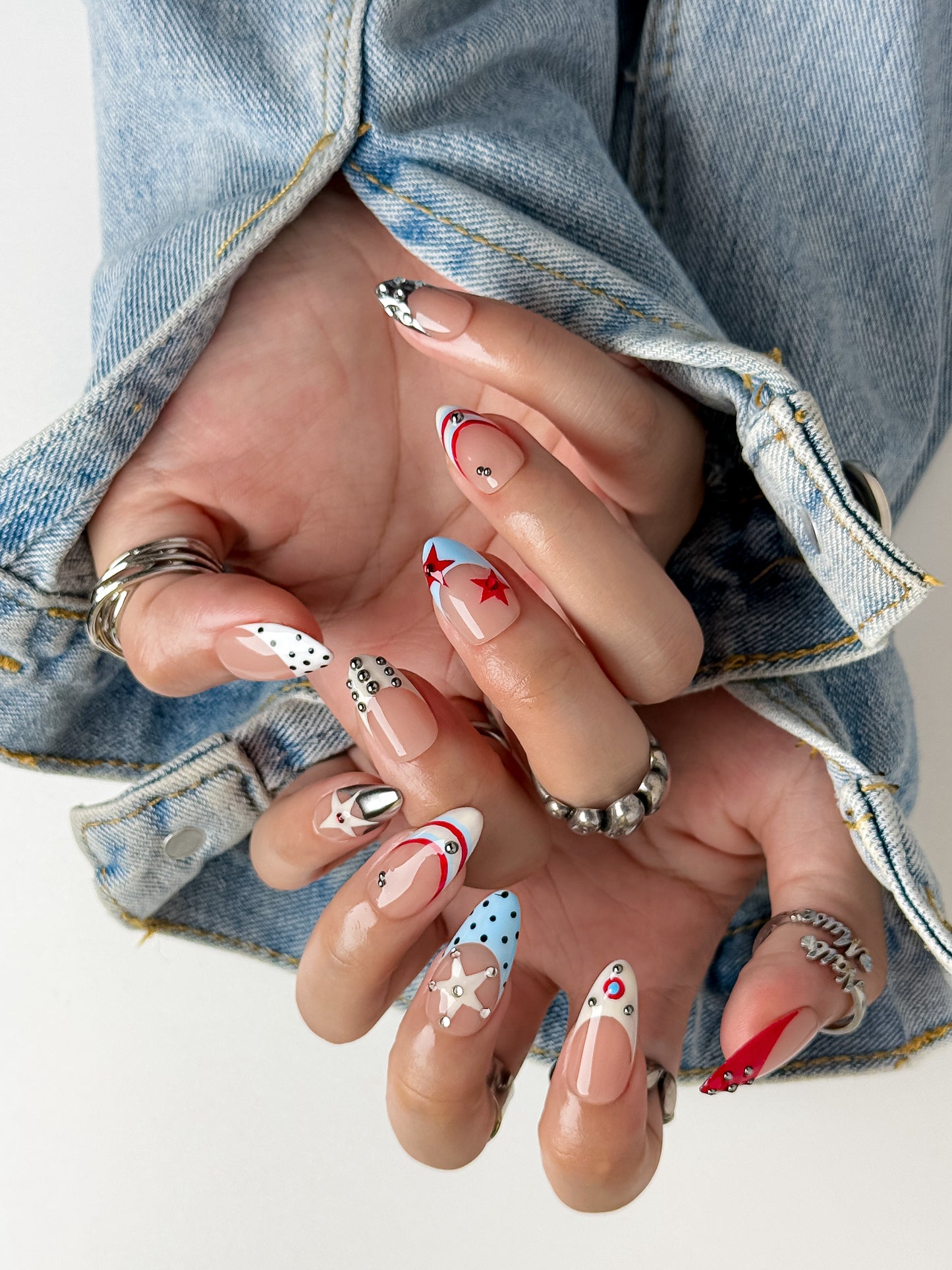Rodeo Star almond press-on nails with vintage Americana design, silver studs and star nail art by NailMusee