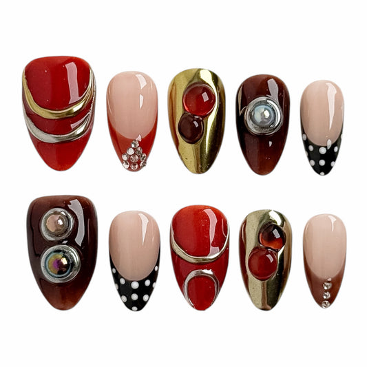 Press-on nails Rubis Caramel avec finition rouge rubis, caramel et ornements dorés, style bijou vintage élégant pour un usage quotidien.